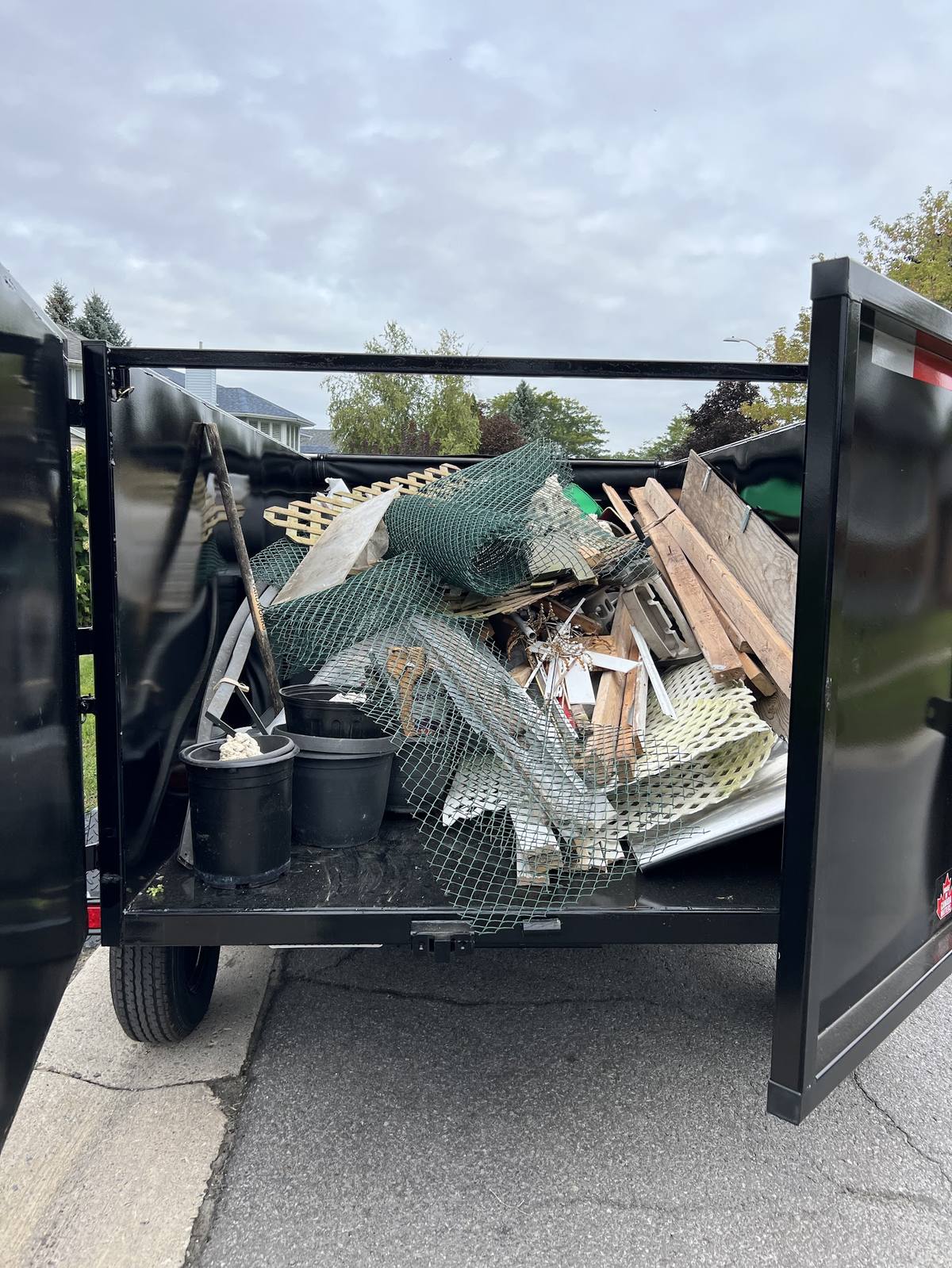 Loaded junk removal trailer with household materials